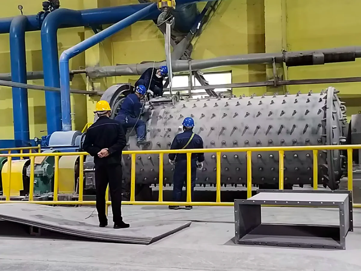 Technicians inspecting a ball mill at a project site